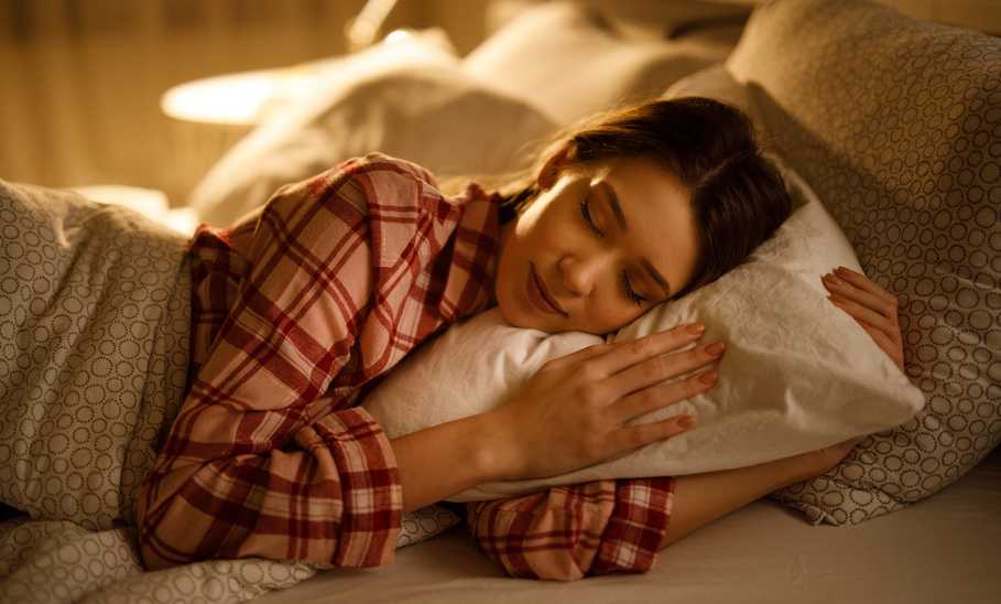 Woman sleeping in bed hugging soft white pillow