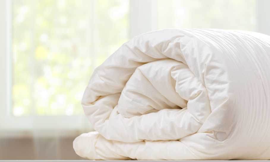 folded rolls duvet is lying on the dresser 